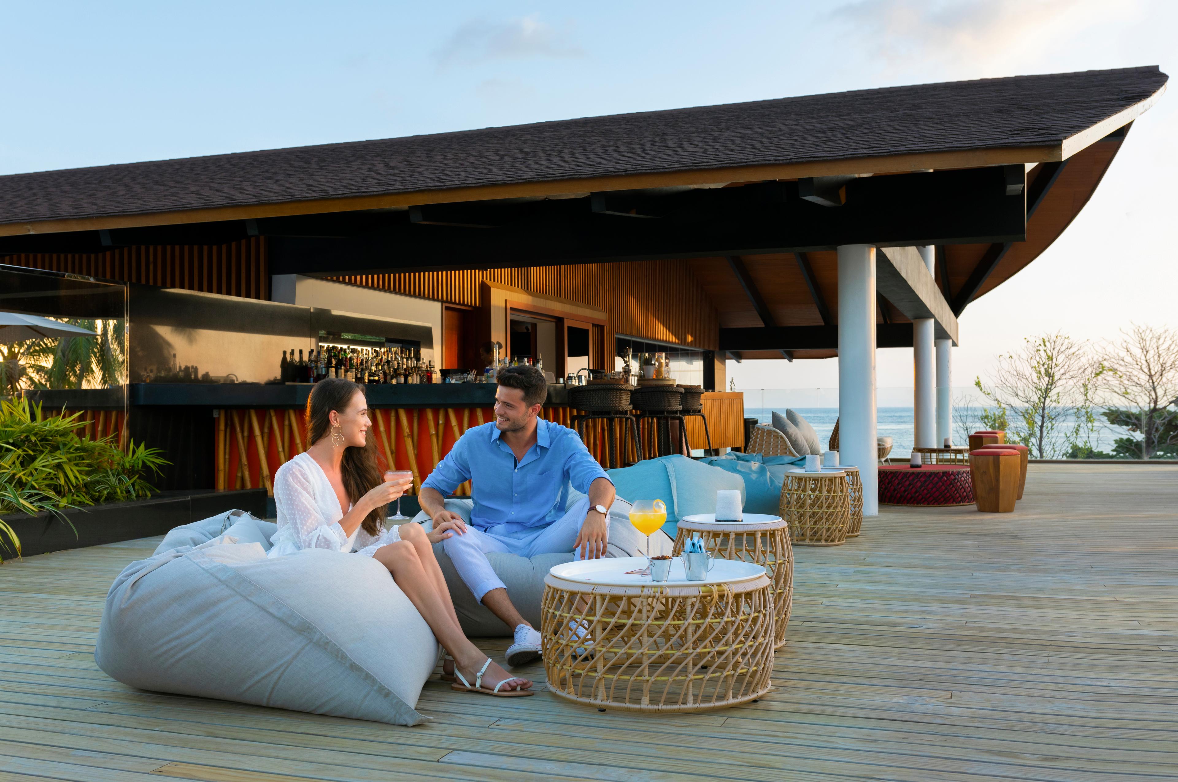 The Westin Maldives Miriandhoo Resort - Couple at Sunset Bar .jpg